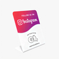 iPhone being tapped against the Instagram Stand to show the instant follow feature for Sydney businesses.